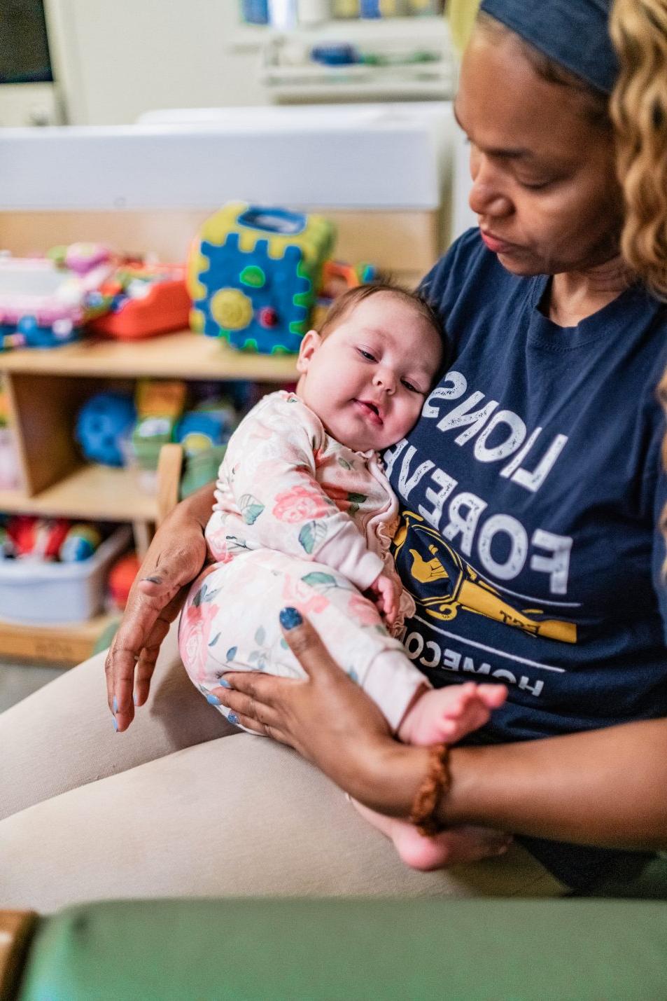 attentive employee holding a sleeping baby.